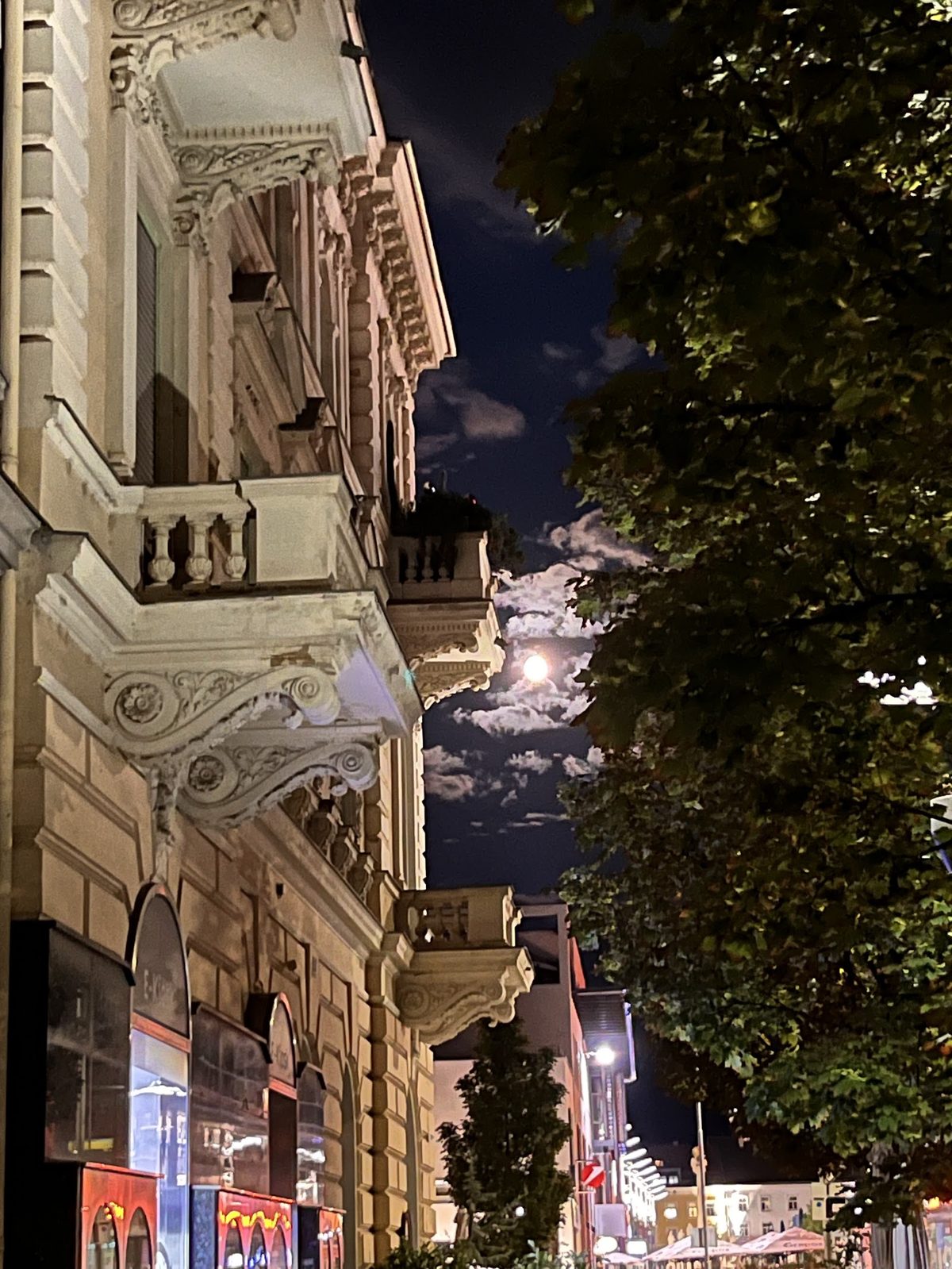 Historische Hausfassade mit Balkonen am beleuchteten Hauptplatz in der Nacht