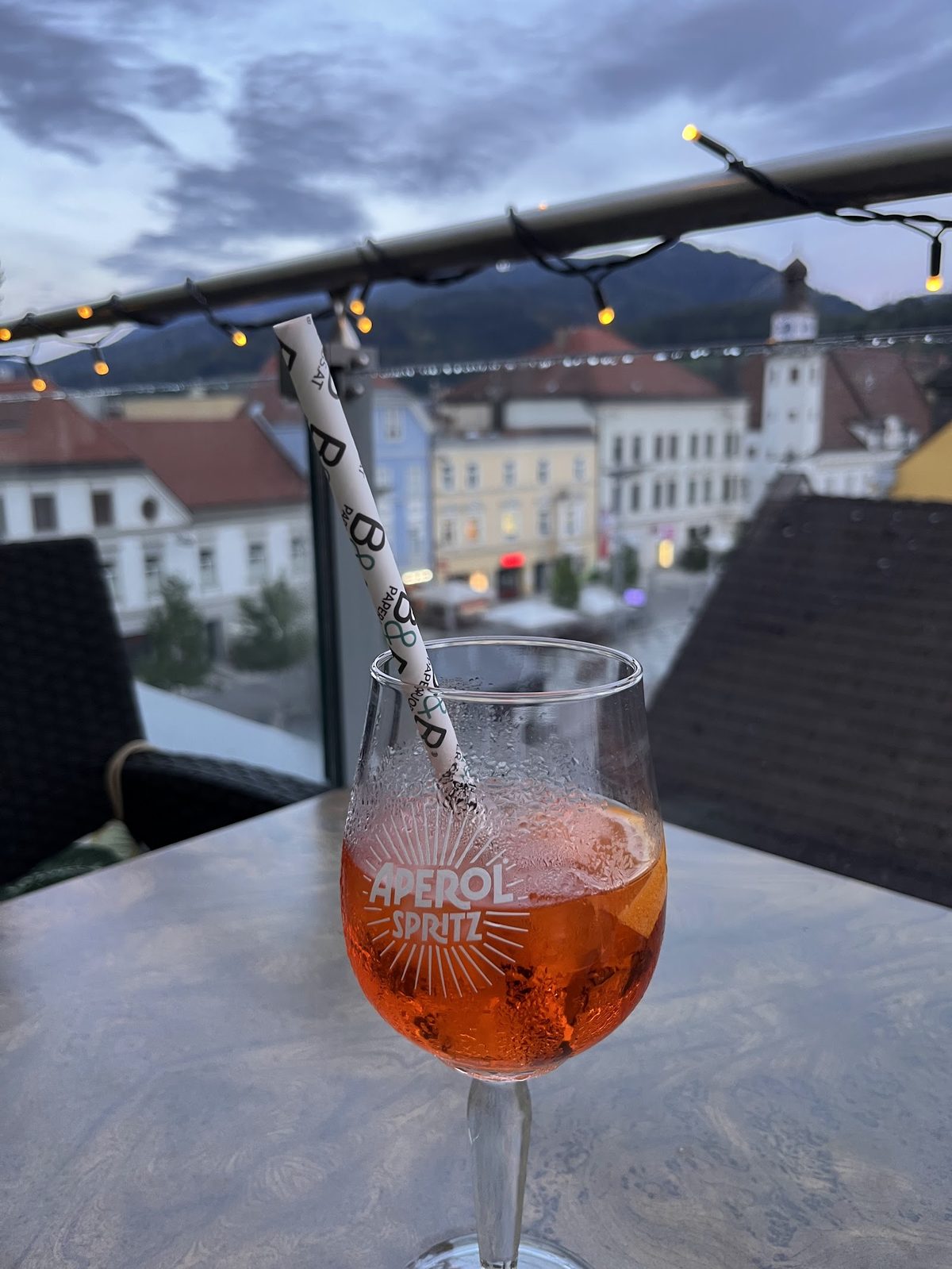 Aperitif im Glas auf einem Tisch mit Blick über die Stadt