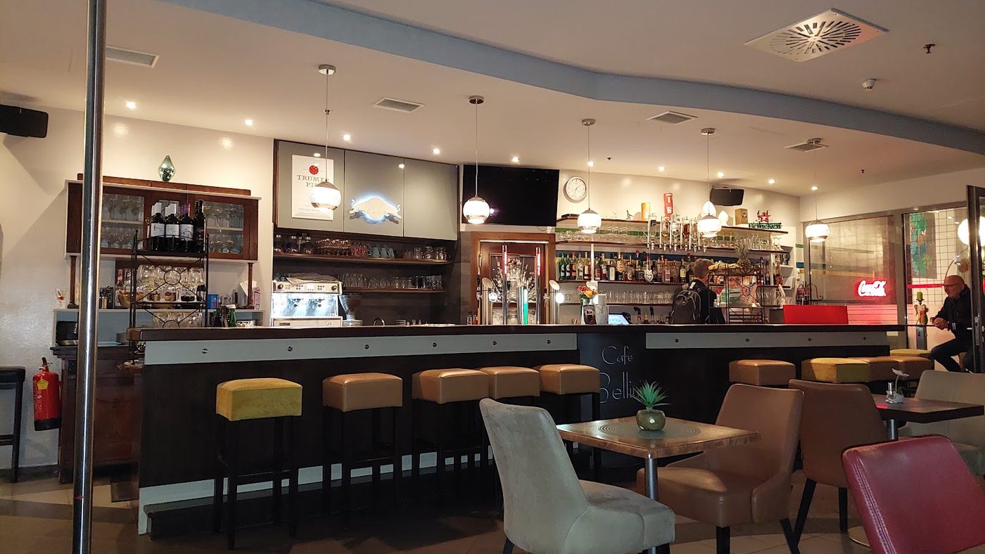 Die Bar im Café Bellini mit Theke, Hockern und warmem Licht