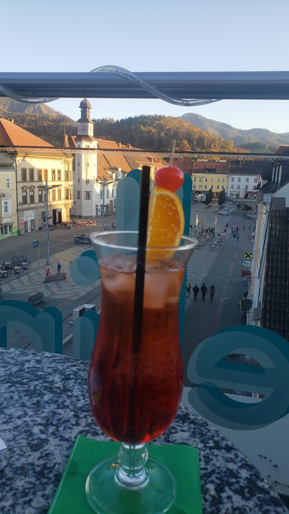 Roter Cocktail im Glas auf einem Tisch mit Blick auf die Altstadt